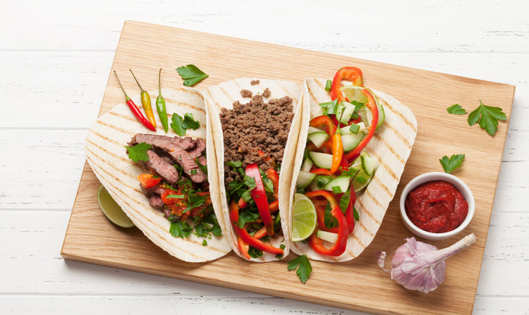 Set of mexican tacos with meat and vegetables in tortilla. Top view on wooden table